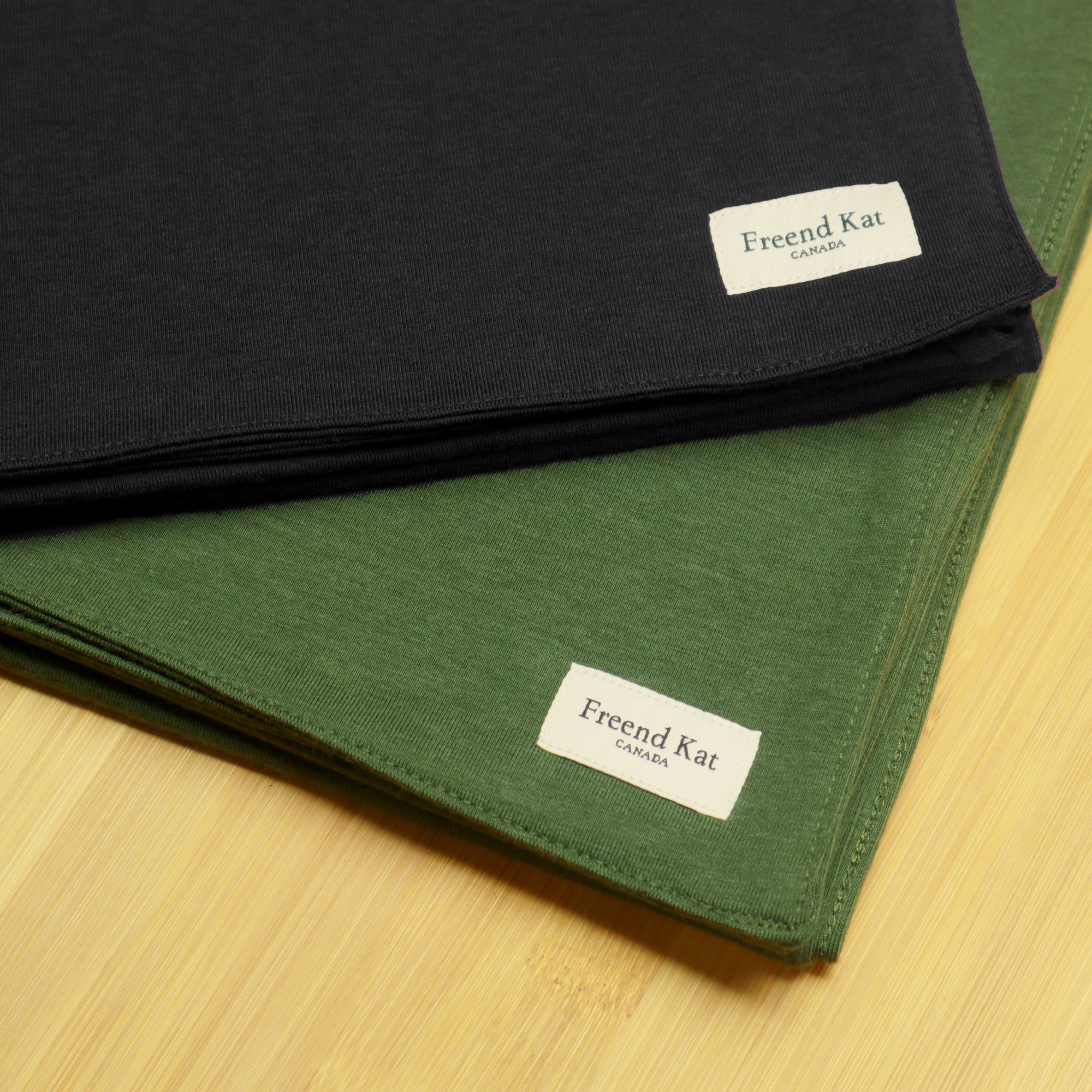 Up close photo of two Anytime Cold Weather Scarves, one in Black and another in Olive Green
